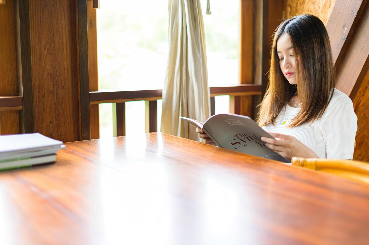 schöne Frau sitzt in einem Café und liest ein Buch foto