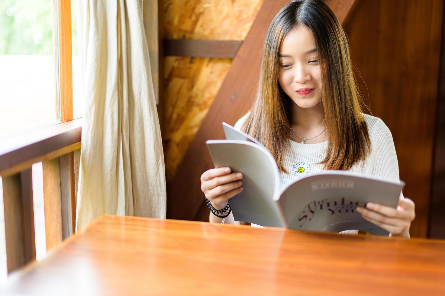 schöne Frau sitzt in einem Café und liest ein Buch foto