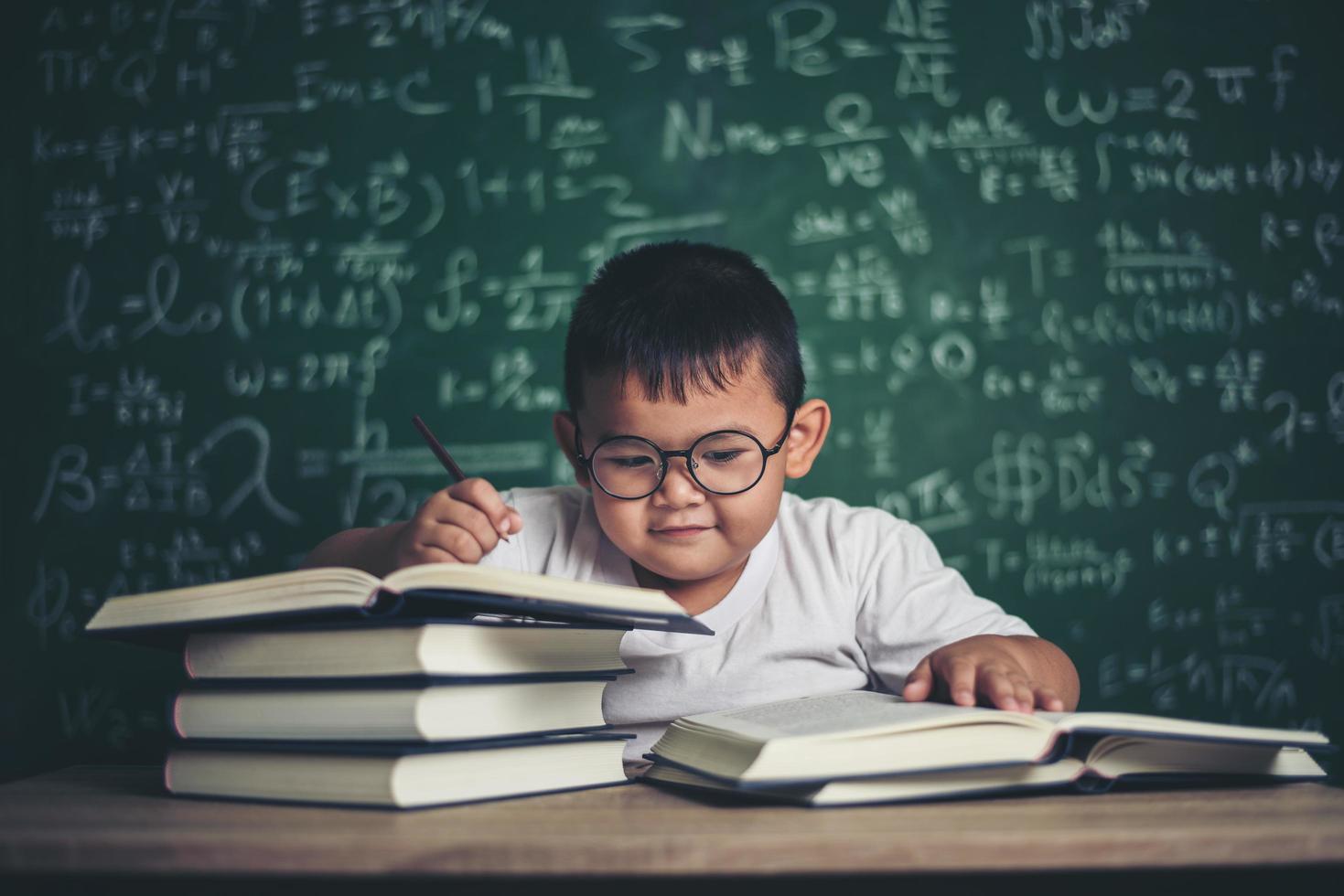 Junge schreibt ein Buch im Klassenzimmer. foto