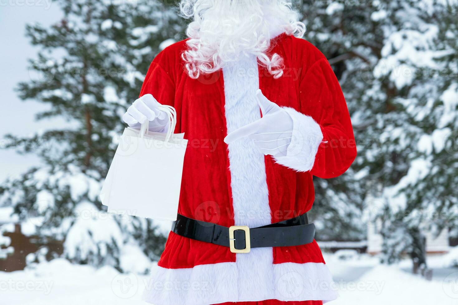 Santa claus draussen im Winter und Schnee Übergabe im Hand Papier Taschen Punkte mit seine Finger. Einkaufen, Verpackung Recycling, handgefertigt, Lieferung zum Weihnachten und Neu Jahr foto