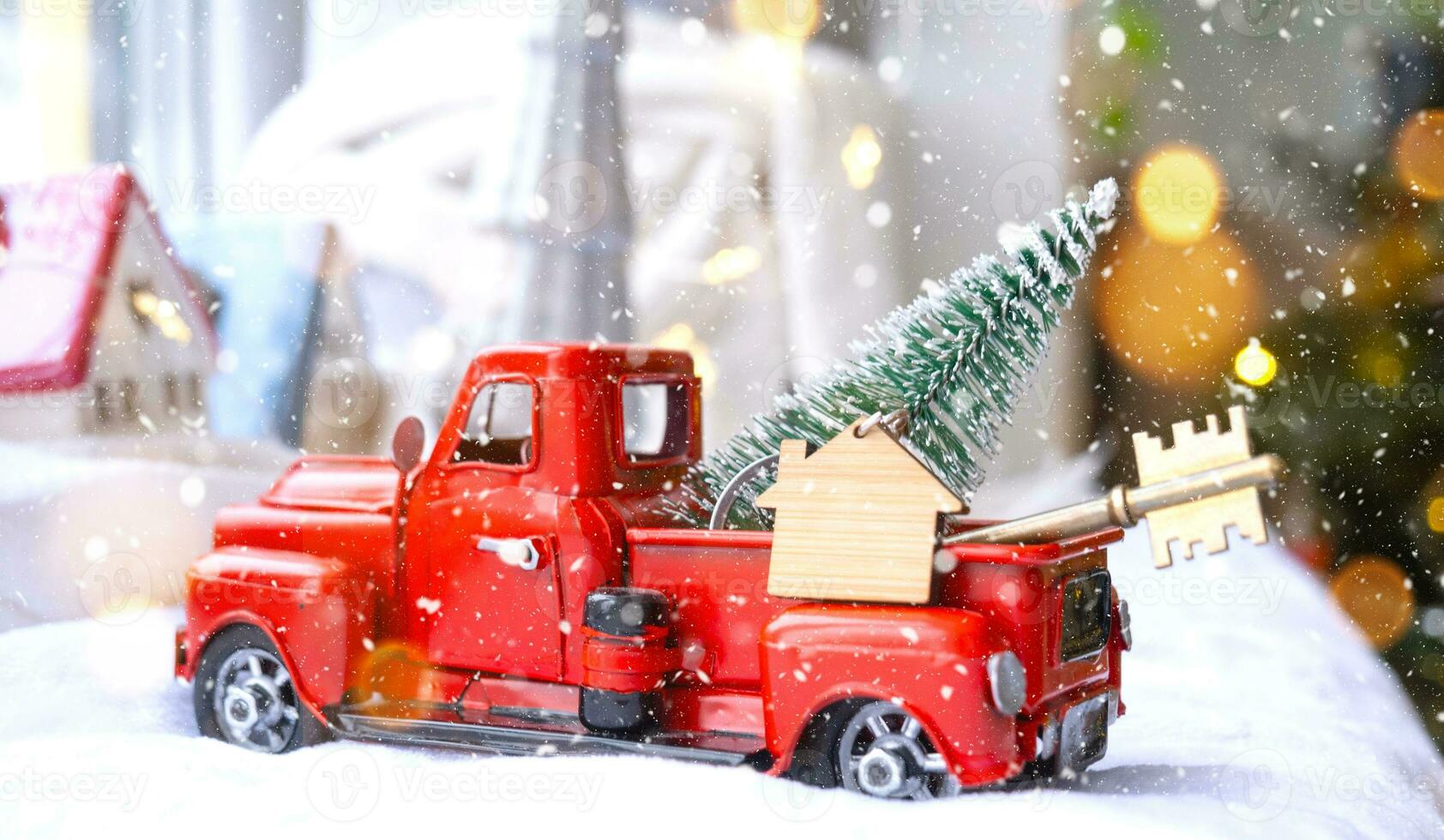 Rotes Retro-Auto mit einem Weihnachtsbaum schmückt mit dem Hausschlüssel im Pickup-Truck zu Weihnachten. Hauskauf, Umzug, Hypothek, Darlehen, Immobilien, Feststimmung, Neujahr foto