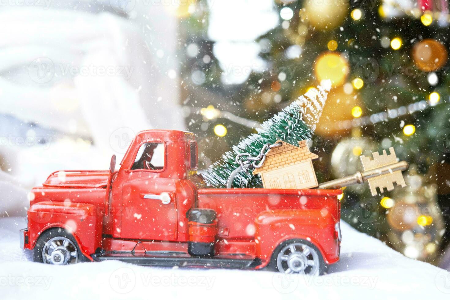 Rotes Retro-Auto mit einem Weihnachtsbaum schmückt mit dem Hausschlüssel im Pickup-Truck zu Weihnachten. Hauskauf, Umzug, Hypothek, Darlehen, Immobilien, Feststimmung, Neujahr foto