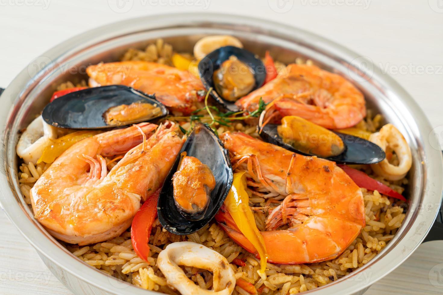 Meeresfrüchte-Paella mit Garnelen, Venusmuscheln, Miesmuscheln auf Safranreis foto