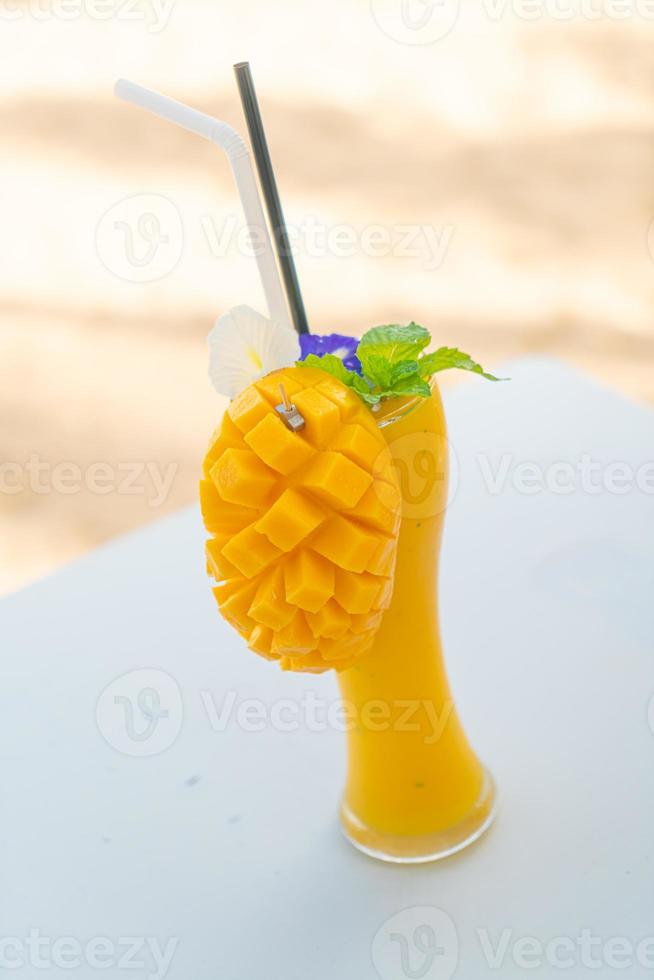 Mango-Smoothies mit Meeresstrand-Hintergrund foto