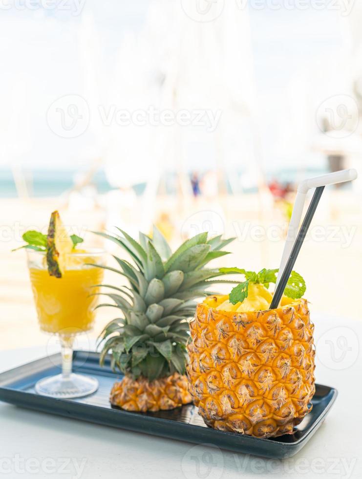 Ananas-Smoothies mit Meeresstrand-Hintergrund foto