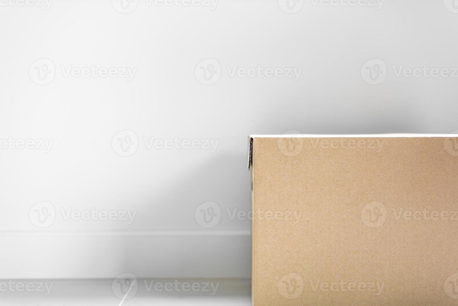 Kastenpaket Paket für die Postzustellung auf Boden mit grauer Wand foto