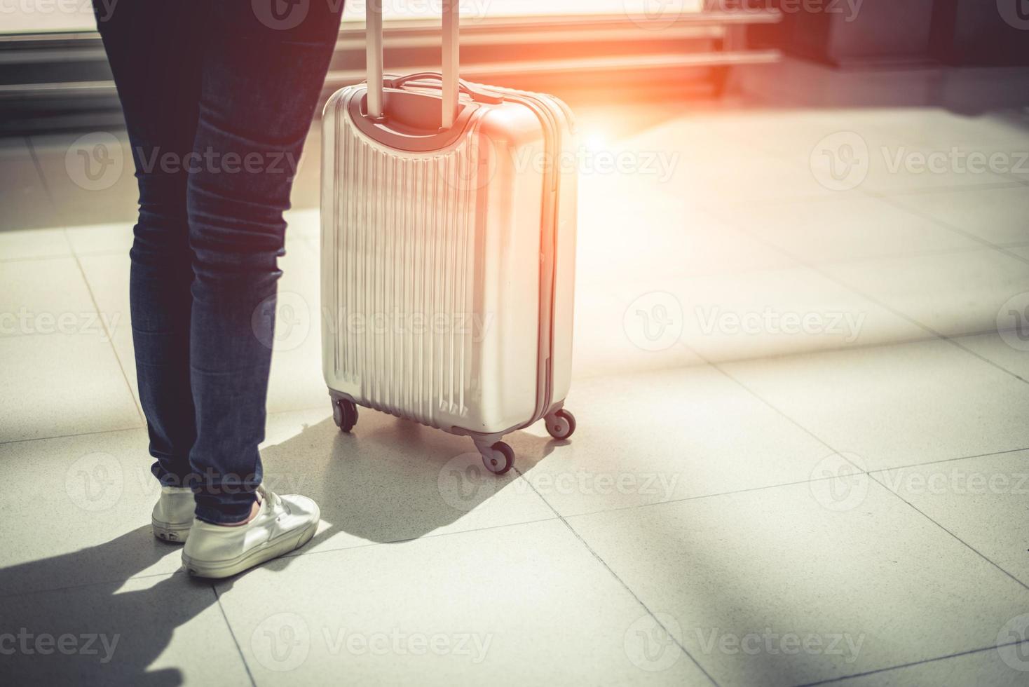 Frau und Koffer Trolley Gepäck im Flughafen hautnah foto