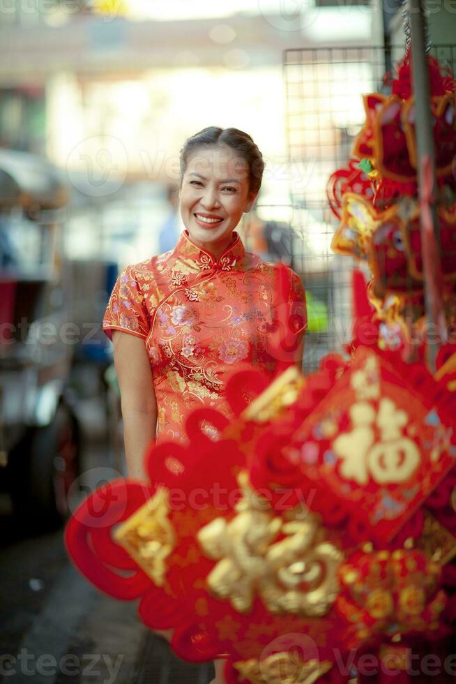asiatisch Frau tragen Chinesisch Tradition Kleider mit Chinesisch Bambus Ventilator lächelnd Gesicht im yaowarat Straße China Stadt, Dorf von Bangkok Thailand foto