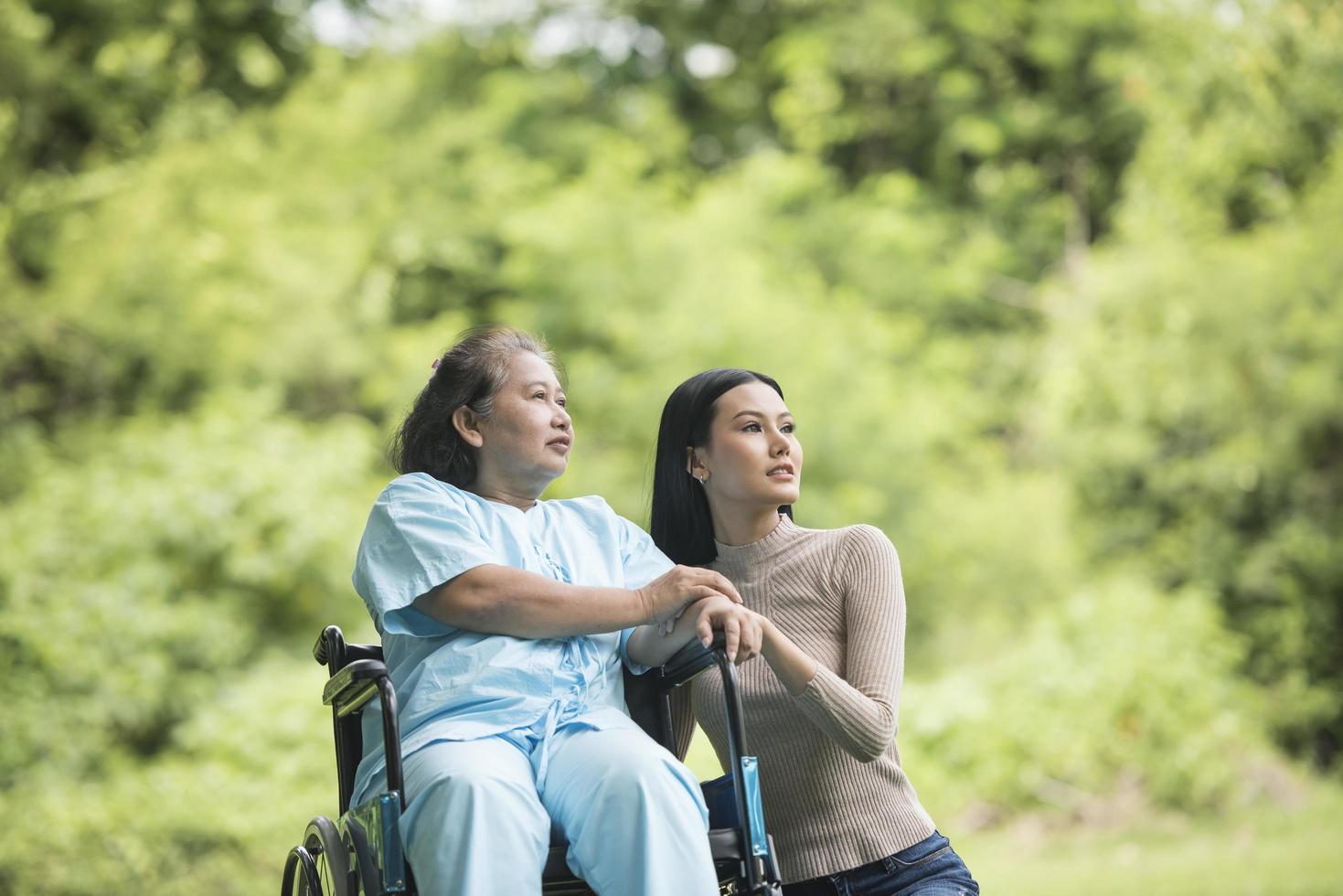Enkelin im Gespräch mit ihrer Großmutter im Rollstuhl sitzend foto