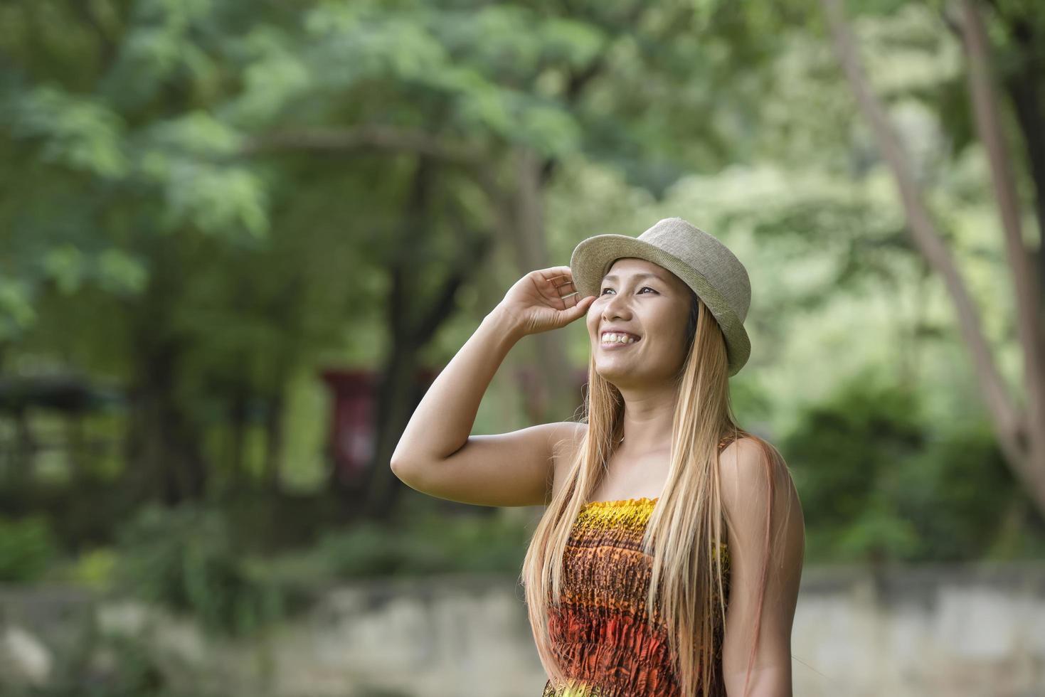 glückliche junge Frau lächelt und geht im Park spazieren foto