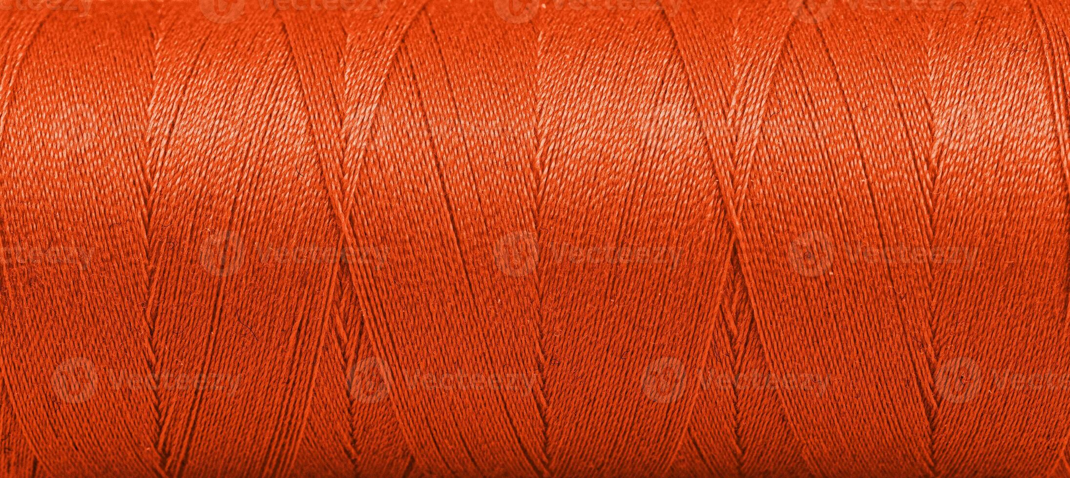 Textur von Fäden im ein Spule von Orange Farbe auf ein Weiß Hintergrund foto