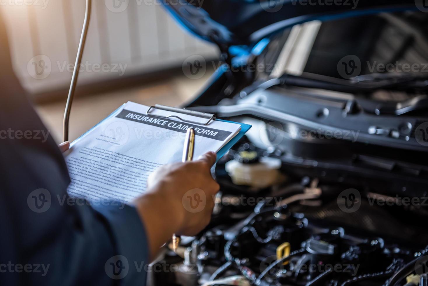 Automechaniker hält Zwischenablage und überprüft das Wartungsfahrzeug foto