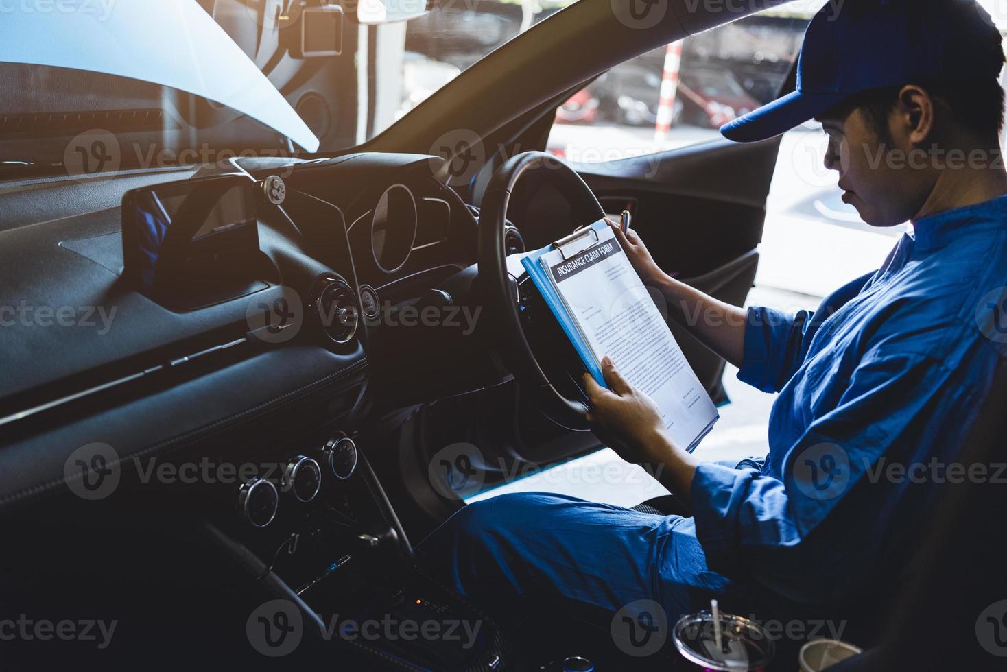 Mechaniker, der die Zwischenablage im Inneren des Autos zum Wartungsfahrzeug überprüft foto