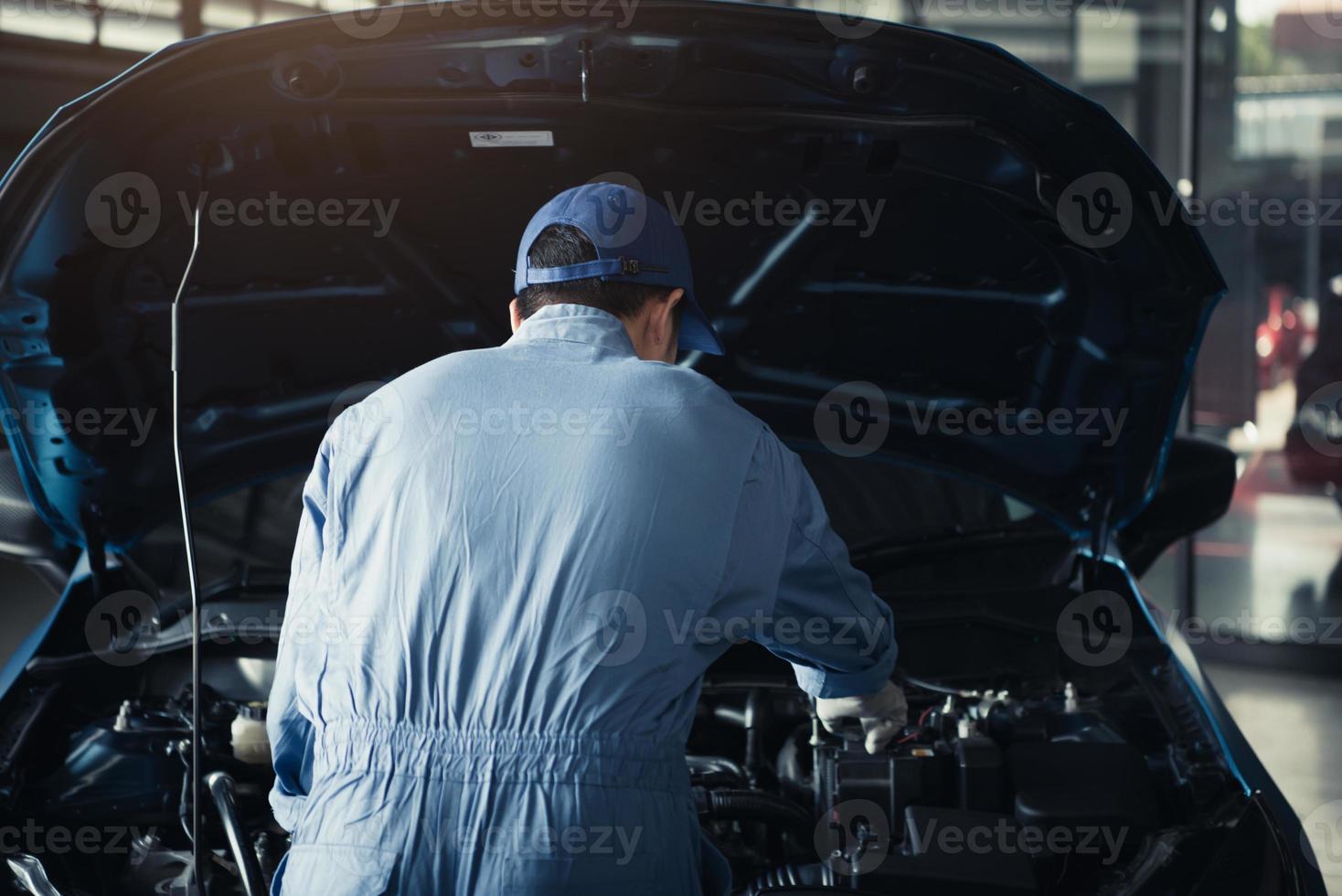 Automechaniker, der die Motorhaube für die interne Überprüfung zur Wartung öffnet foto