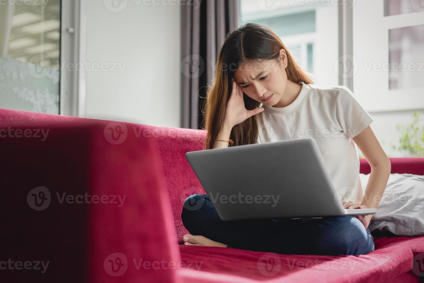 erschöpfte Geschäftsfrau, die Kopfschmerzen hat, während sie Laptop benutzt foto