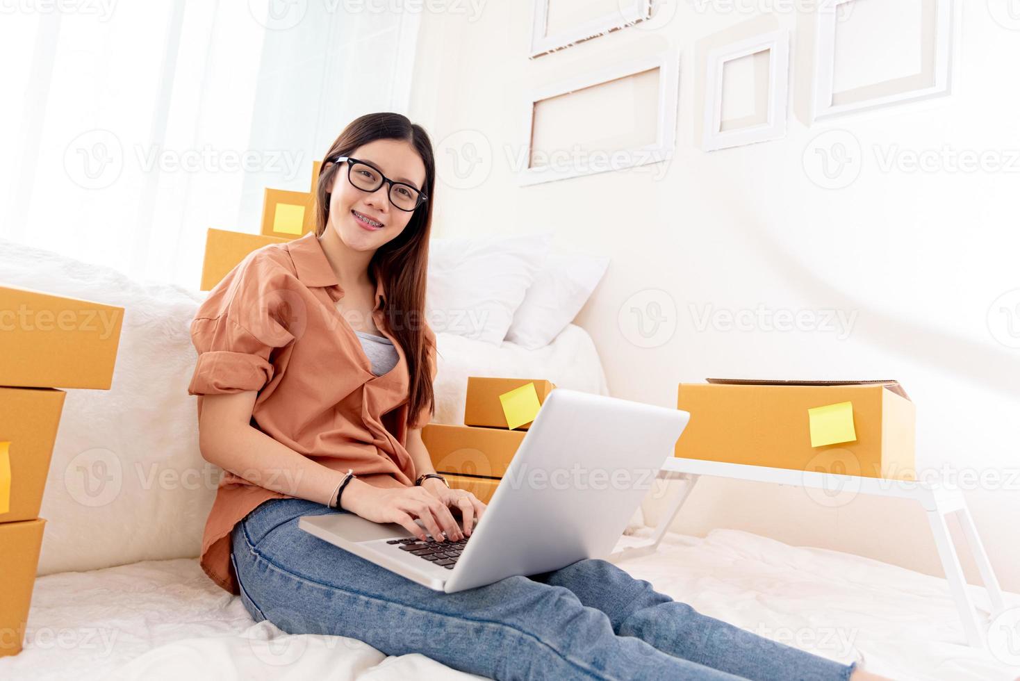 Schönheit asiatische Frau mit Laptop für Kundenbetreuung im Schlafzimmer foto