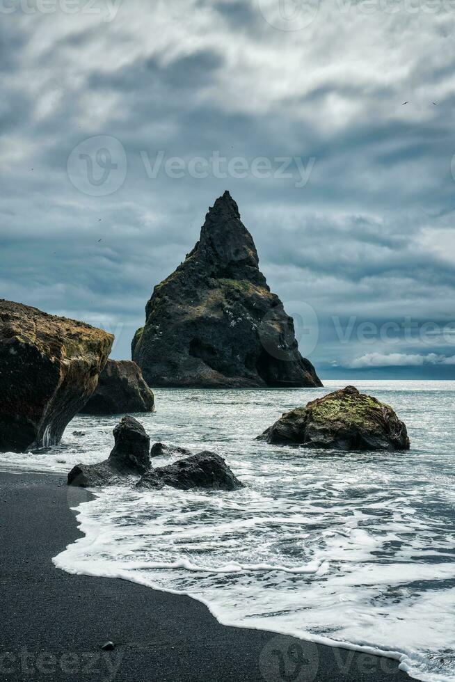 launisch Reynisdragar natürlich Felsen Formation auf reynisfjara schwarz Sand Strand im atlantisch Ozean beim Island foto