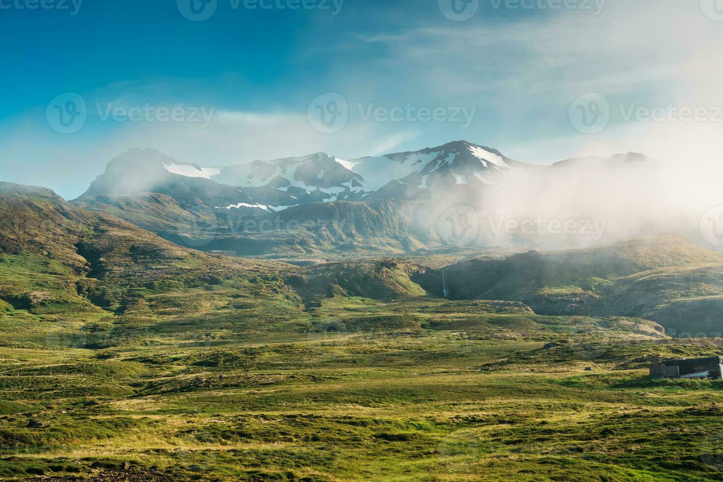 Aussicht von ländlich Szene mit Nebel bedeckt Berg und winzig Wasserfall im Sommer- beim Island foto