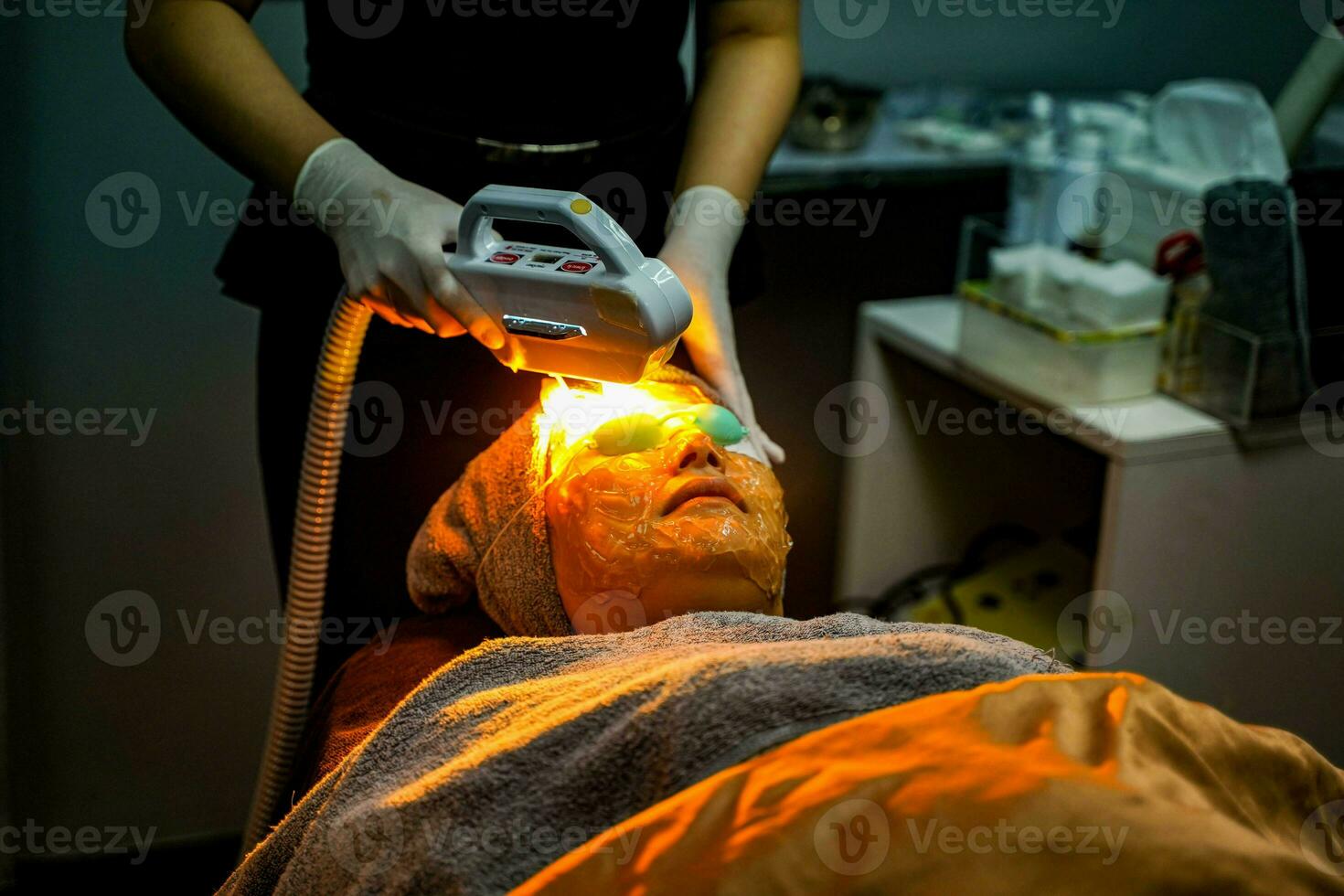 Nahansicht asiatisch Schönheit Frau Empfang Laser- Behandlung durch Fachmann Kosmetikerin Wohlbefinden im Schönheit Klinik. foto