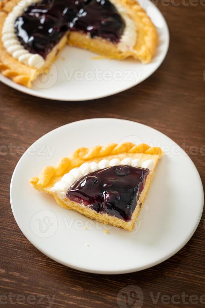 Blaubeerkäsekuchen auf weißem Teller foto