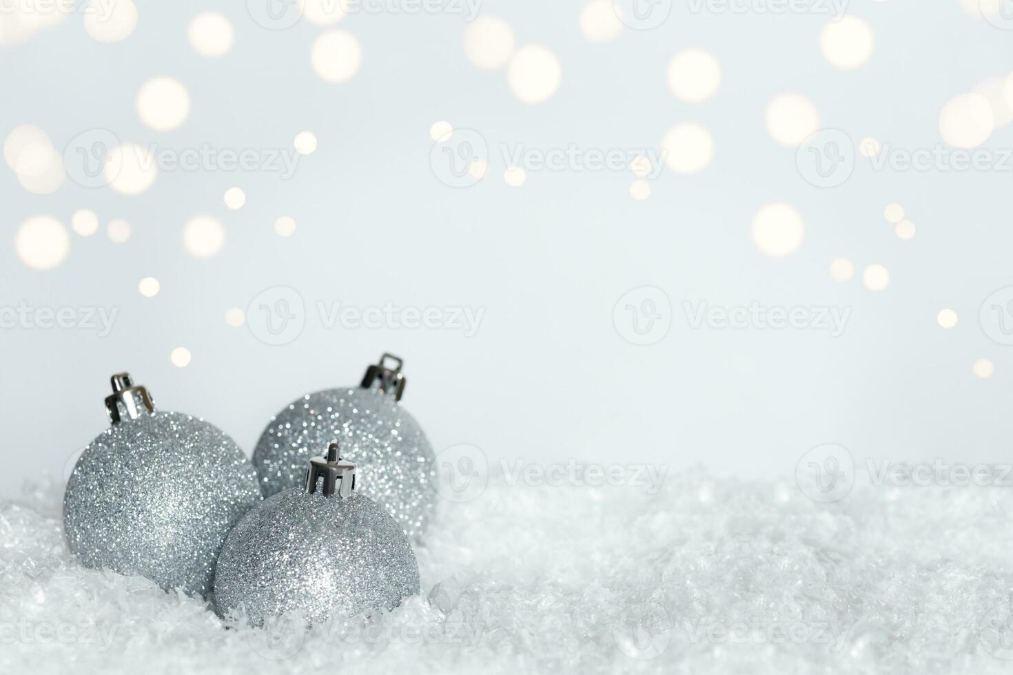 Silber funkeln Weihnachten Ornamente auf Bett von Schnee auf Weiß Hintergrund mit Bokeh Wirkung. Kopieren Raum foto
