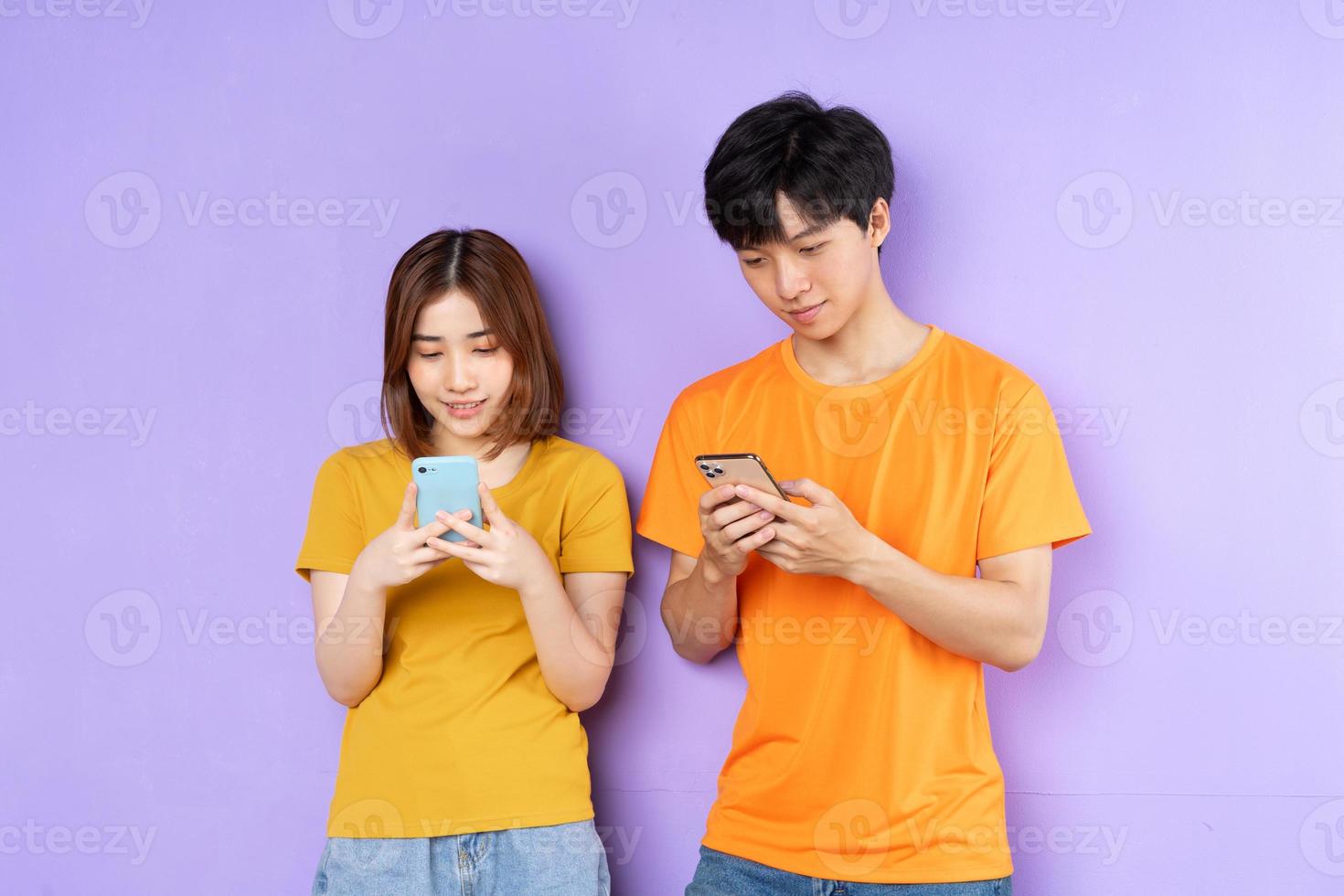 asiatisches Paarporträt, isoliert auf lila Hintergrund foto