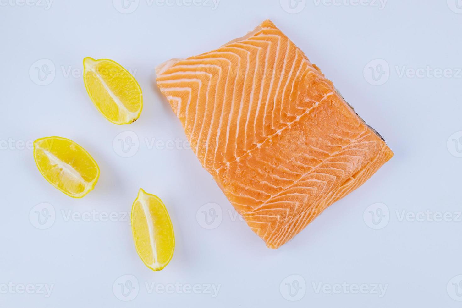 frisches Lachsfilet mit Zitrone auf weißem Hintergrund. foto