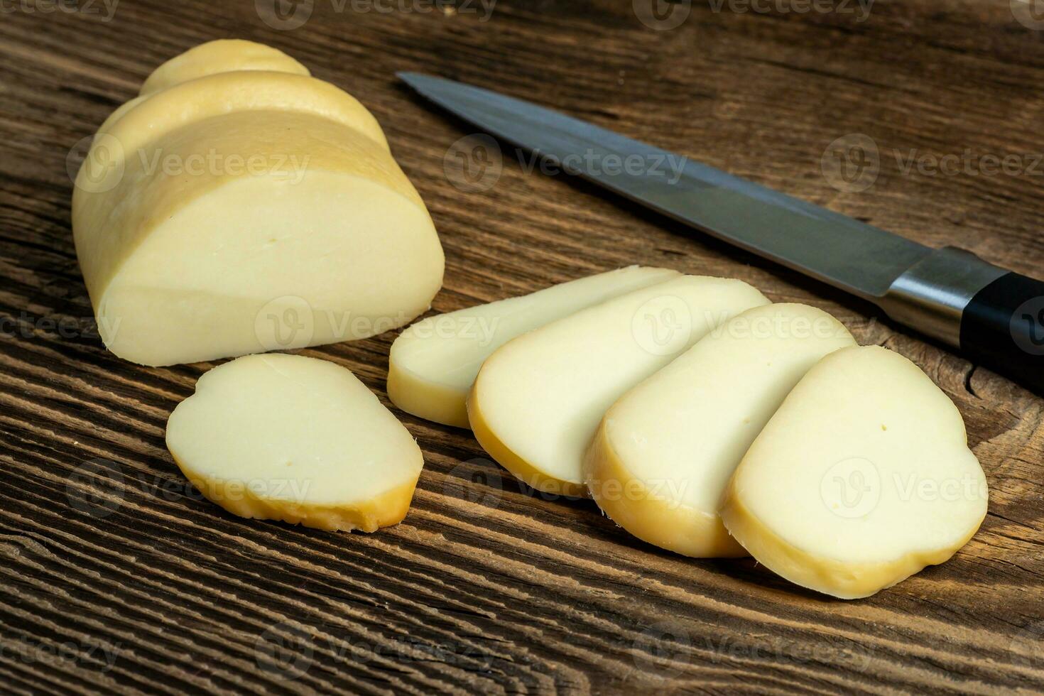 geräuchert schwer Käse auf ein hölzern Tafel mit ein Messer foto