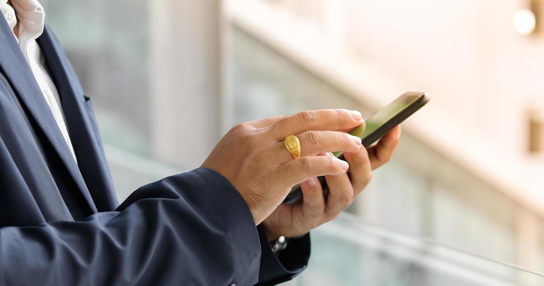 Geschäftsmann mit Telefon für SMS foto