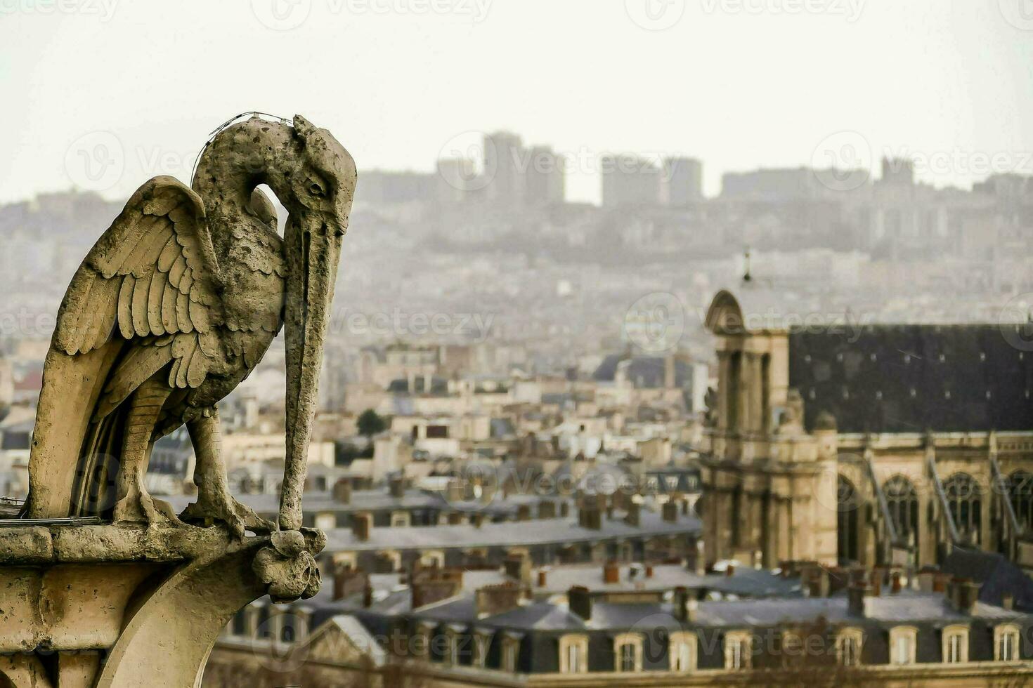 ein Vogel Statue auf oben von ein Gebäude mit Blick auf ein Stadt foto