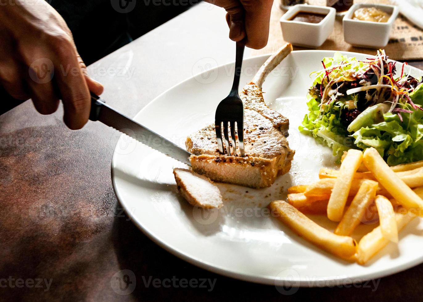 Schweinekotelettsteak mit Salat und Pommes frites foto