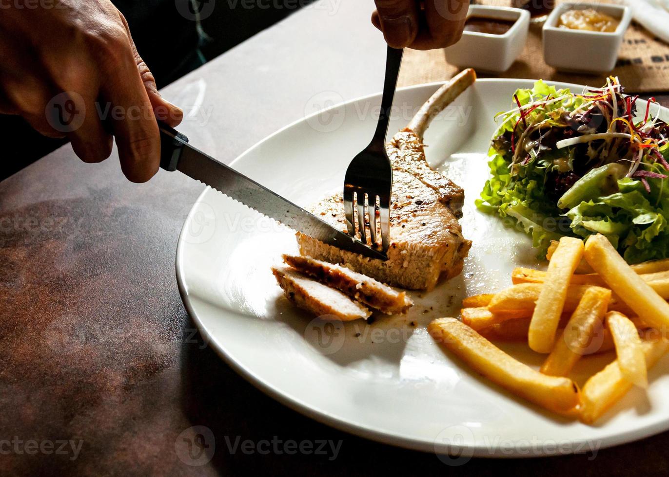 Schweinekotelettsteak mit Salat und Pommes frites foto