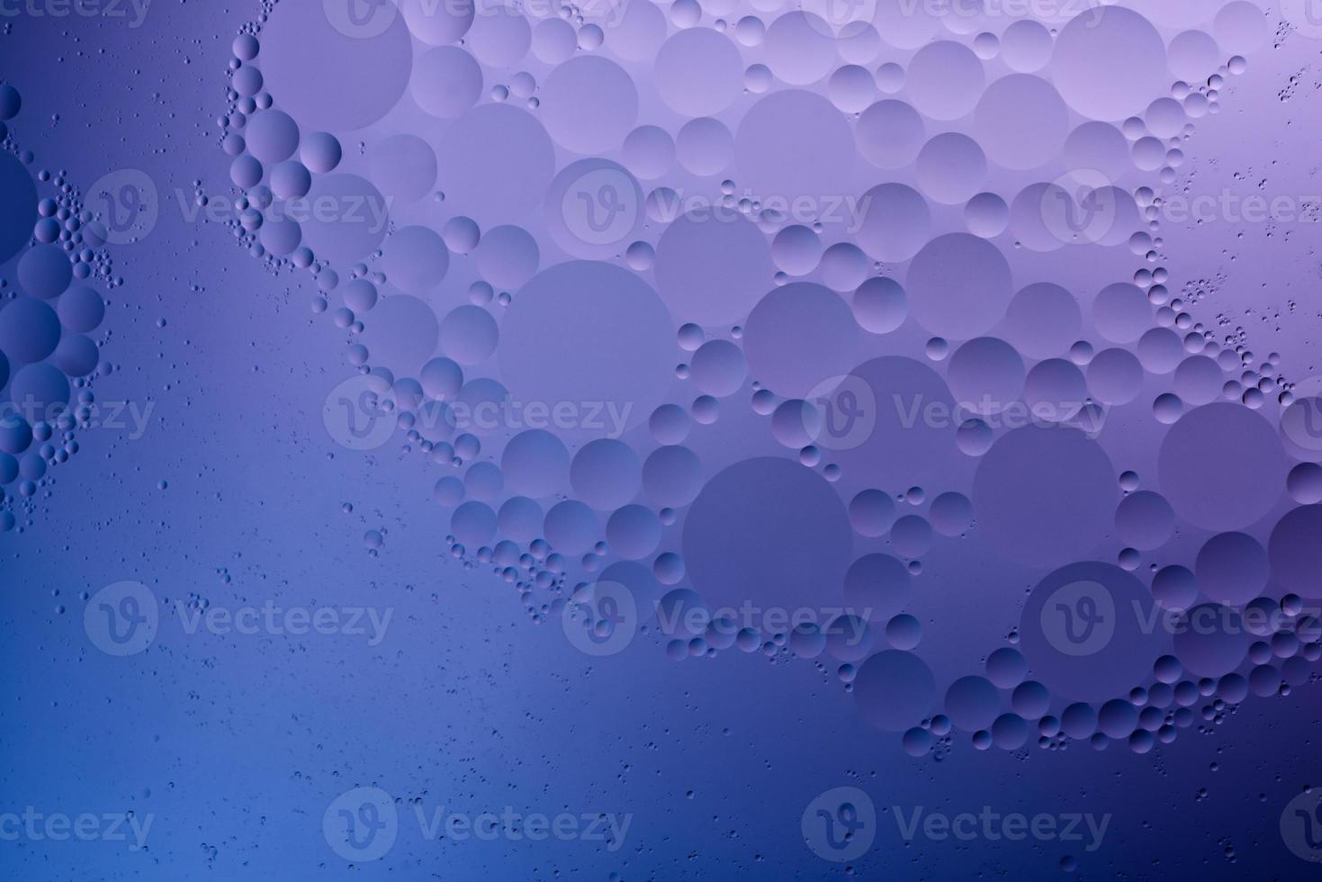 Wasser und Öl, farbiger abstrakter Hintergrund basierend auf blauen, violetten und neonfarbenen Kreisen und Ovalen, Makroabstraktion, echtes Foto. foto