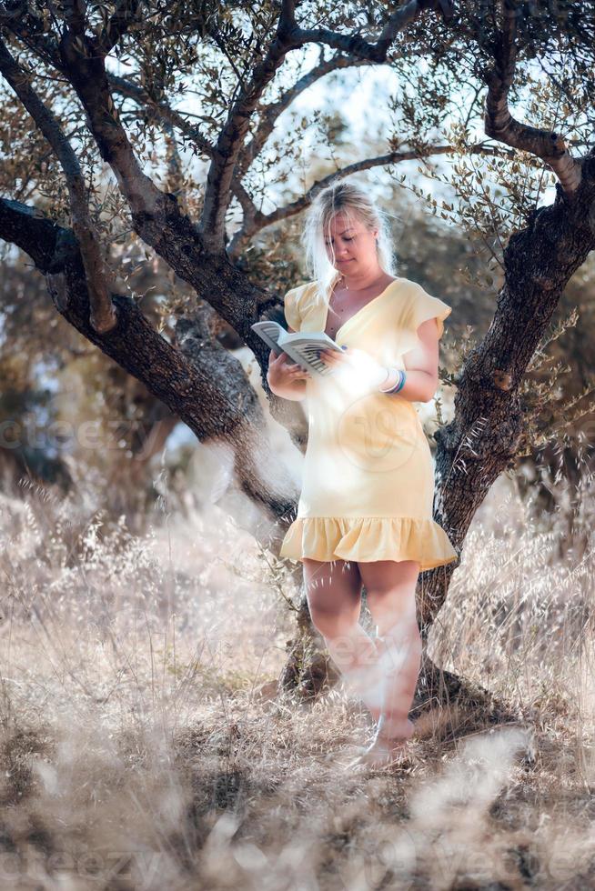 eine barfüßige blonde Frau in einem gelben Sommerkleid foto