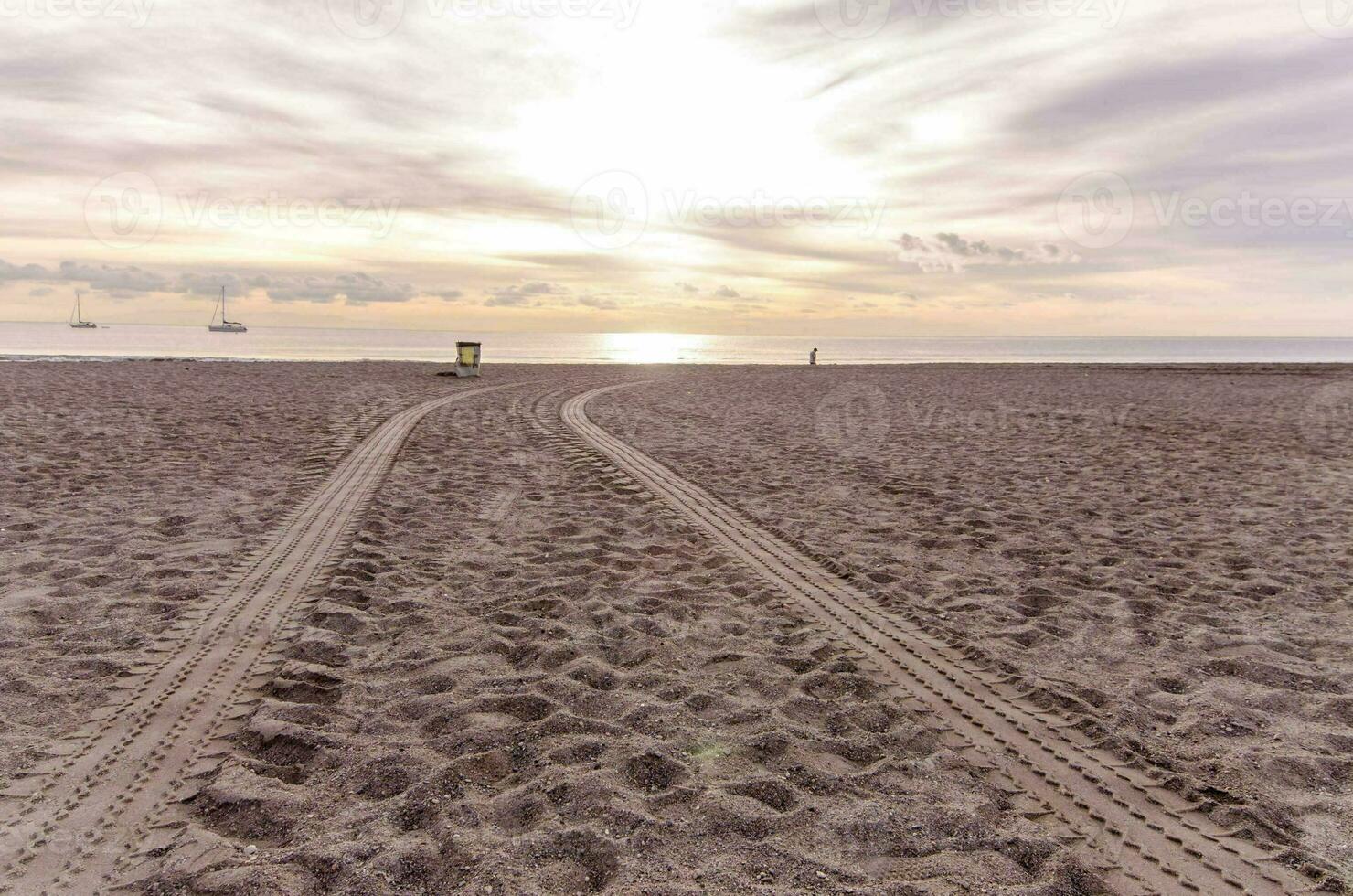 zwei Spuren im das Sand auf das Strand foto