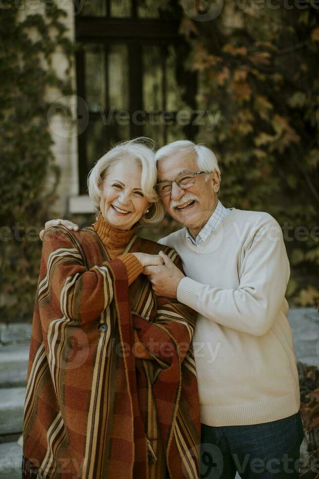 Seniorenpaar umarmt sich im Herbstpark foto