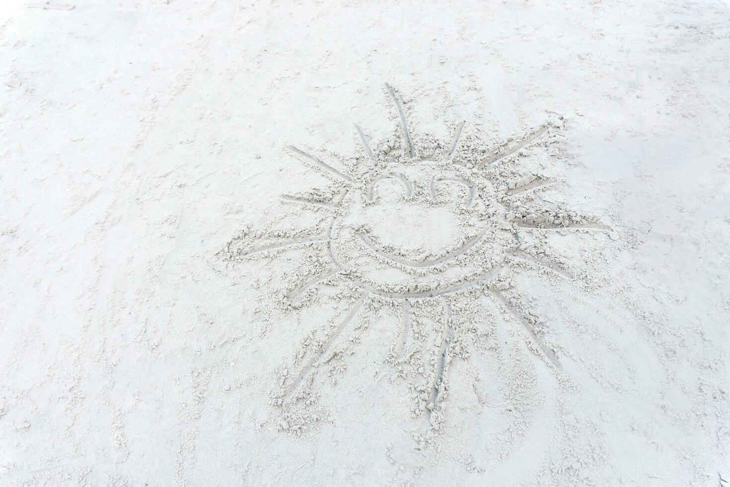 Lächeln Sonne Zeichnung auf ein Weiß Sand Strand foto