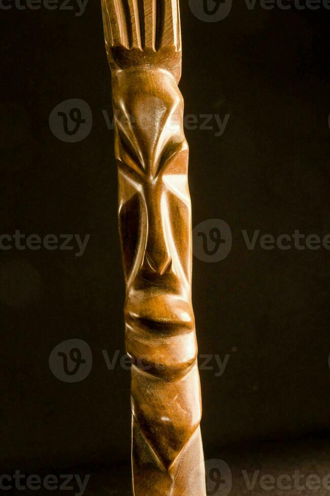 ein hölzern Tiki Statue mit ein Gesicht auf es foto