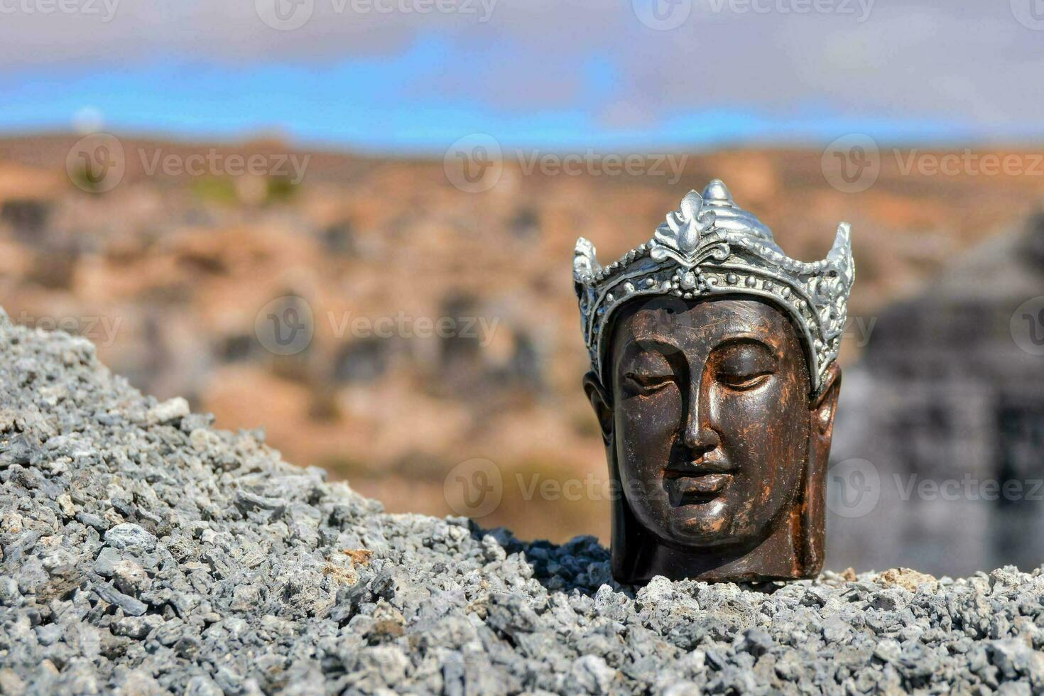 ein Statue von ein Buddha Kopf auf oben von ein Stapel von Felsen foto