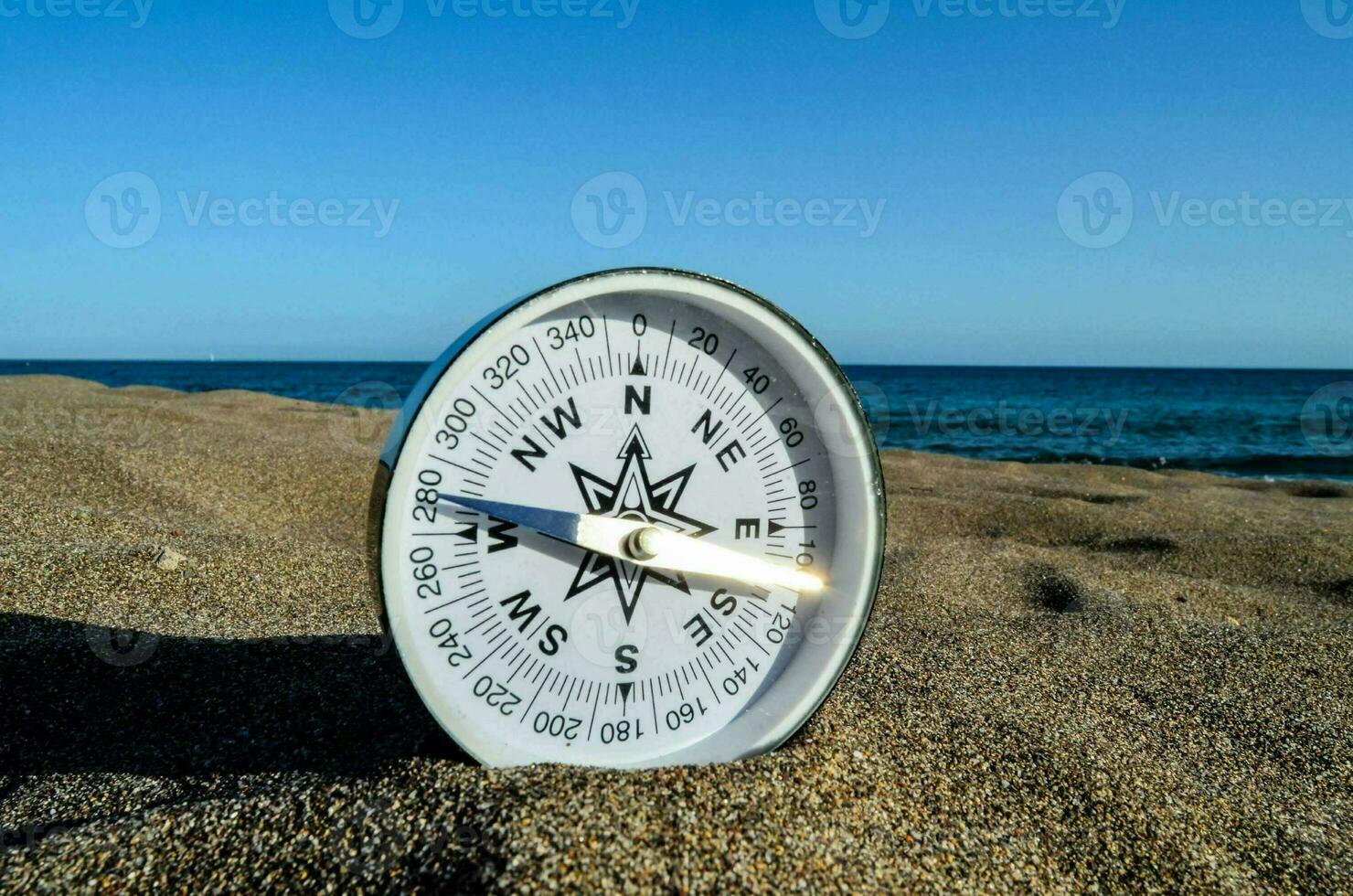 ein Kompass auf das Strand foto