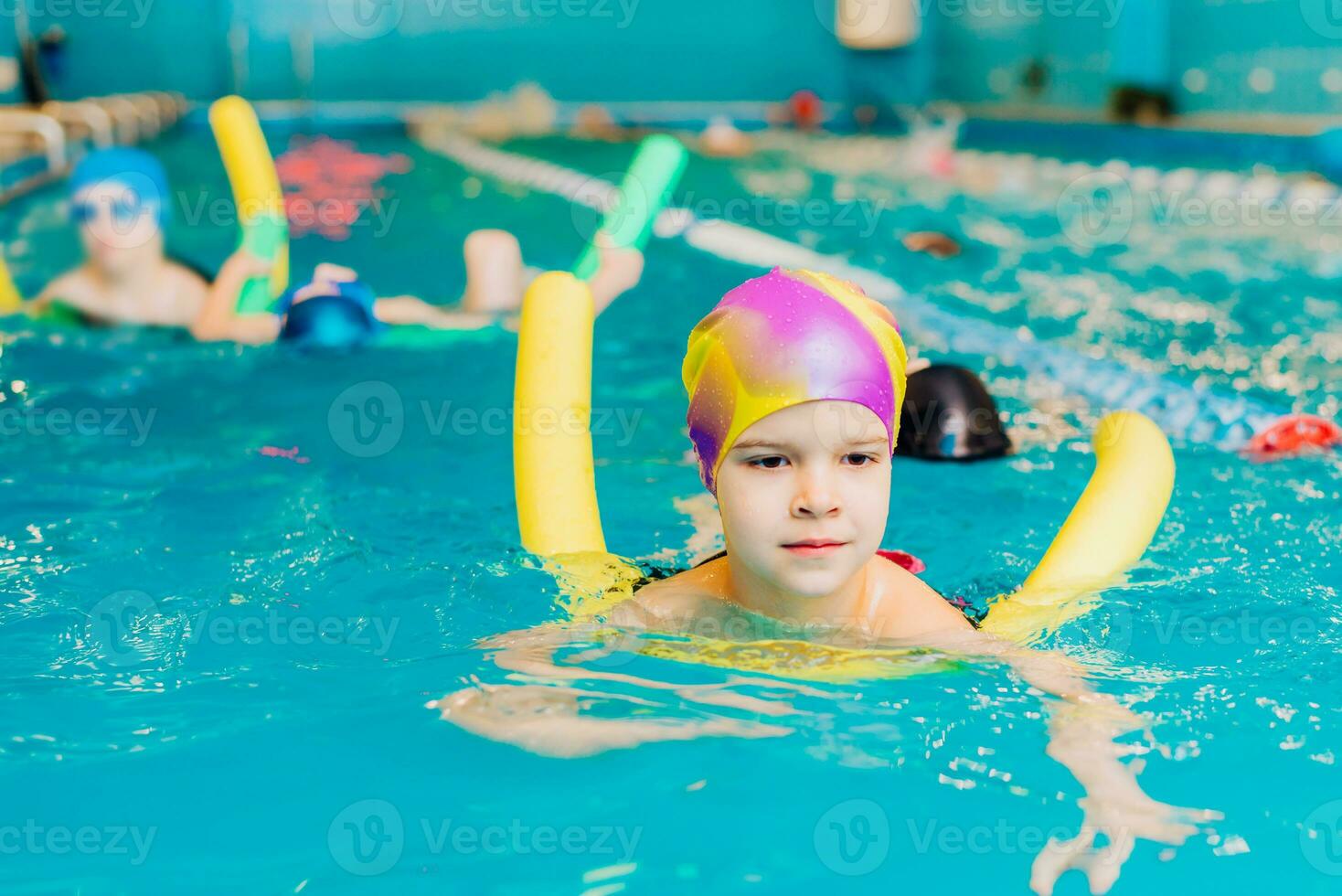 klein Kind schwimmen im ein Innen- Schwimmbad. foto