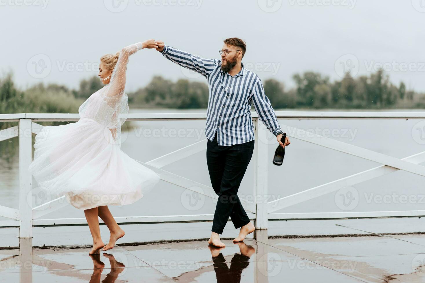 schön gerade verheiratet tanzen barfuß und haben Spaß auf das Seebrücke durch das Wasser. foto