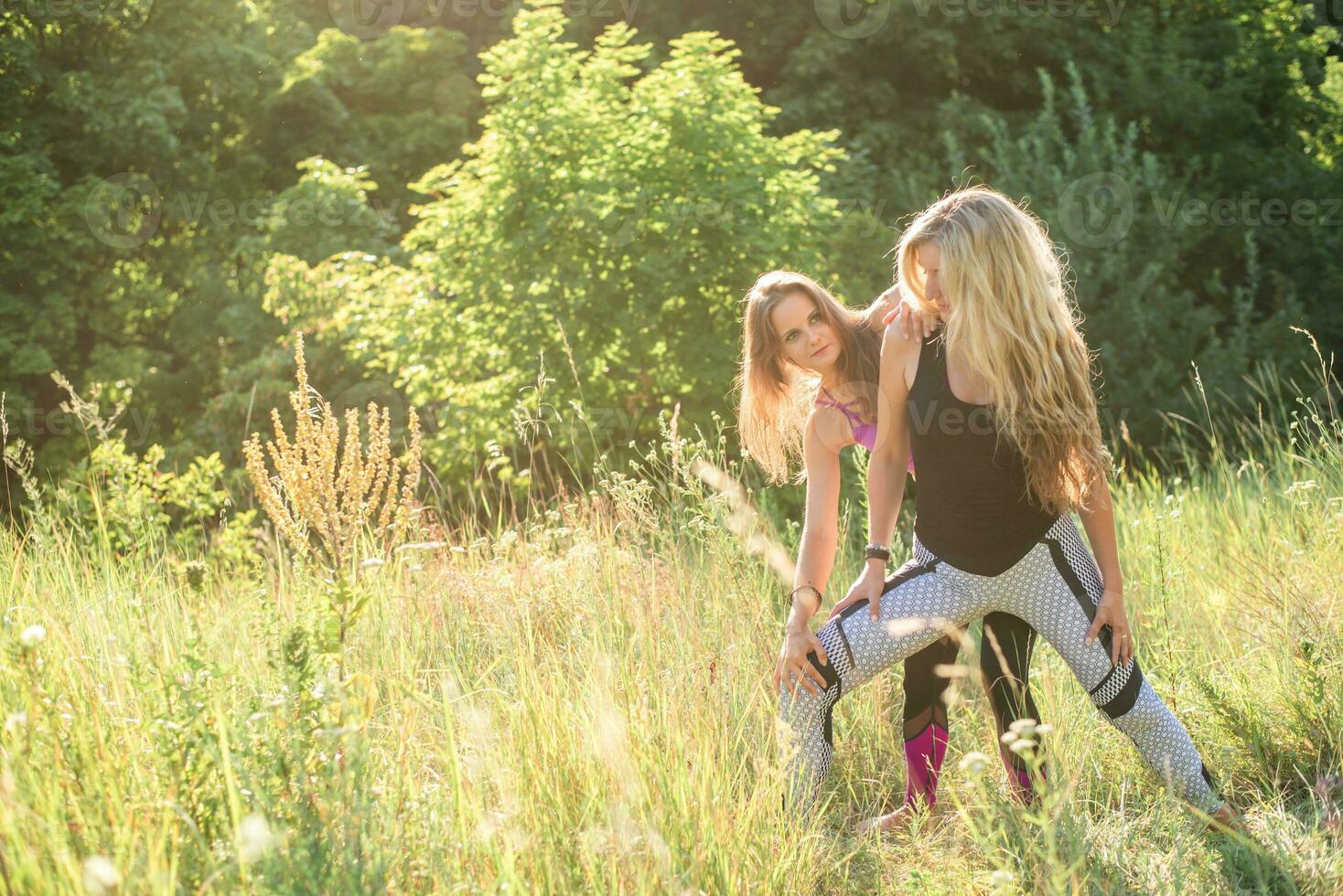 Frau Yoga Lehrer Lehren Anfänger im Natur auf ein sonnig Tag foto