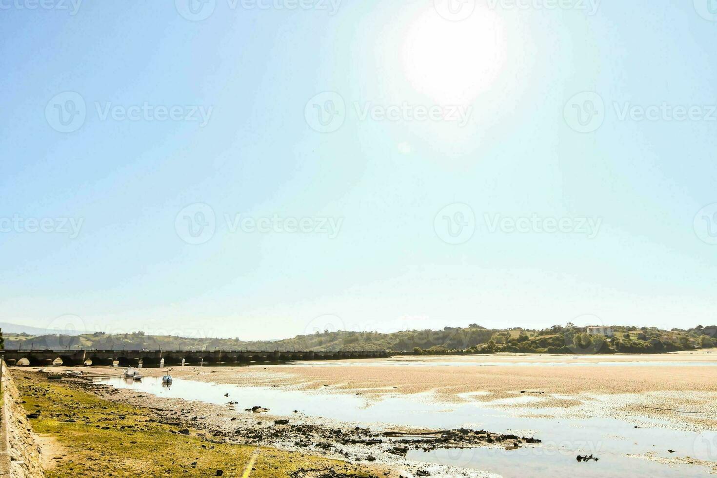 das Sonne scheint hell Über das Wasser und ein sandig Strand foto