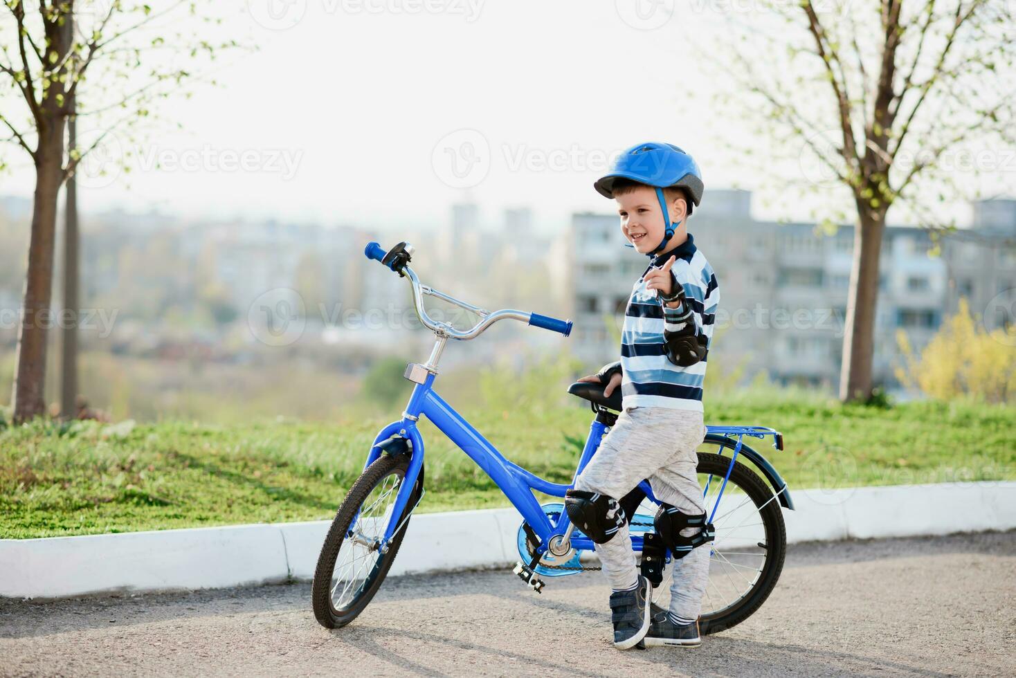 süß Kind im Helm und Schutz steht in der Nähe von seine Fahrrad foto