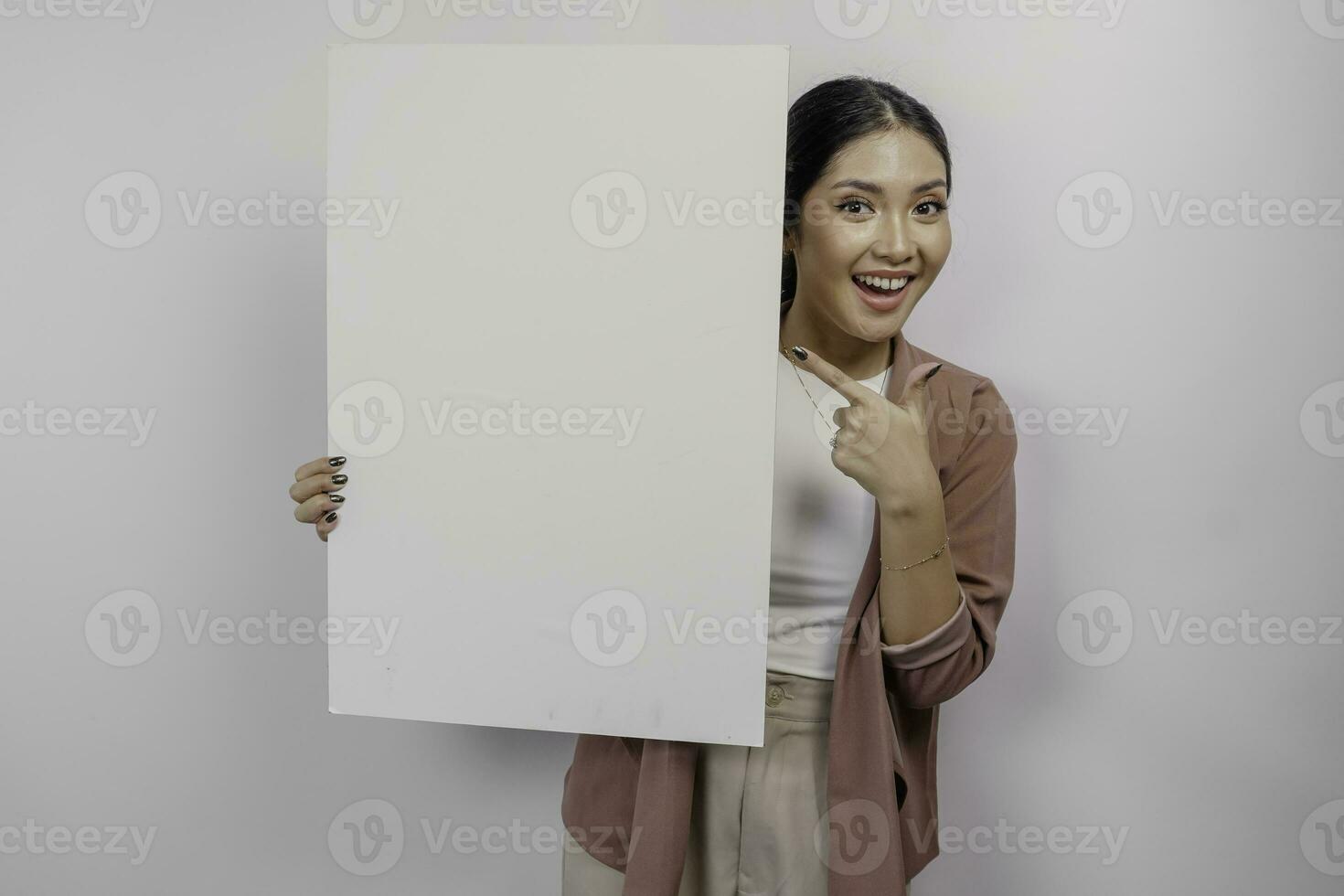 lächelnd jung asiatisch Frau Mitarbeiter halten und zeigen leeren leer Planke, isoliert durch Weiß Hintergrund foto