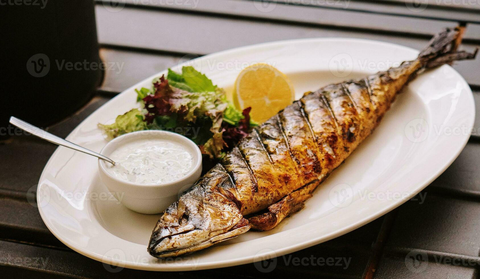 gebraten Fisch mit Fisch Soße schön platziert auf ein Teller foto