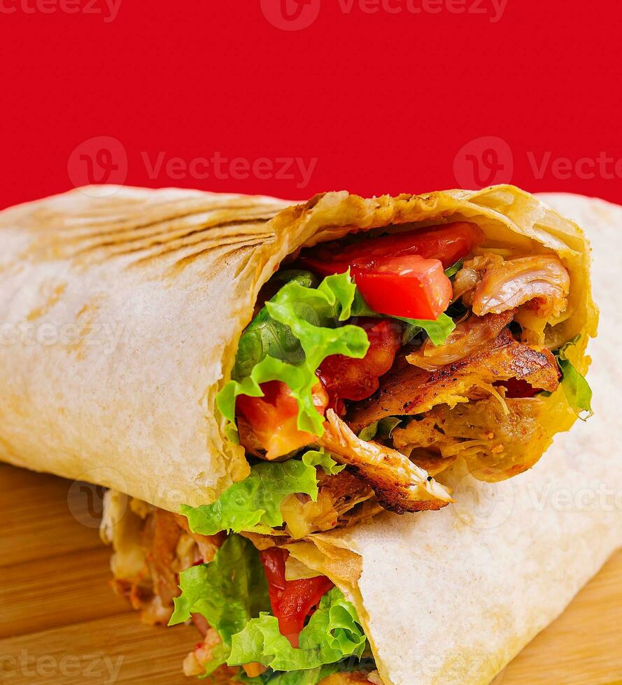 Döner mit Huhn, Tomaten und Grüner Salat auf ein hölzern Tafel foto