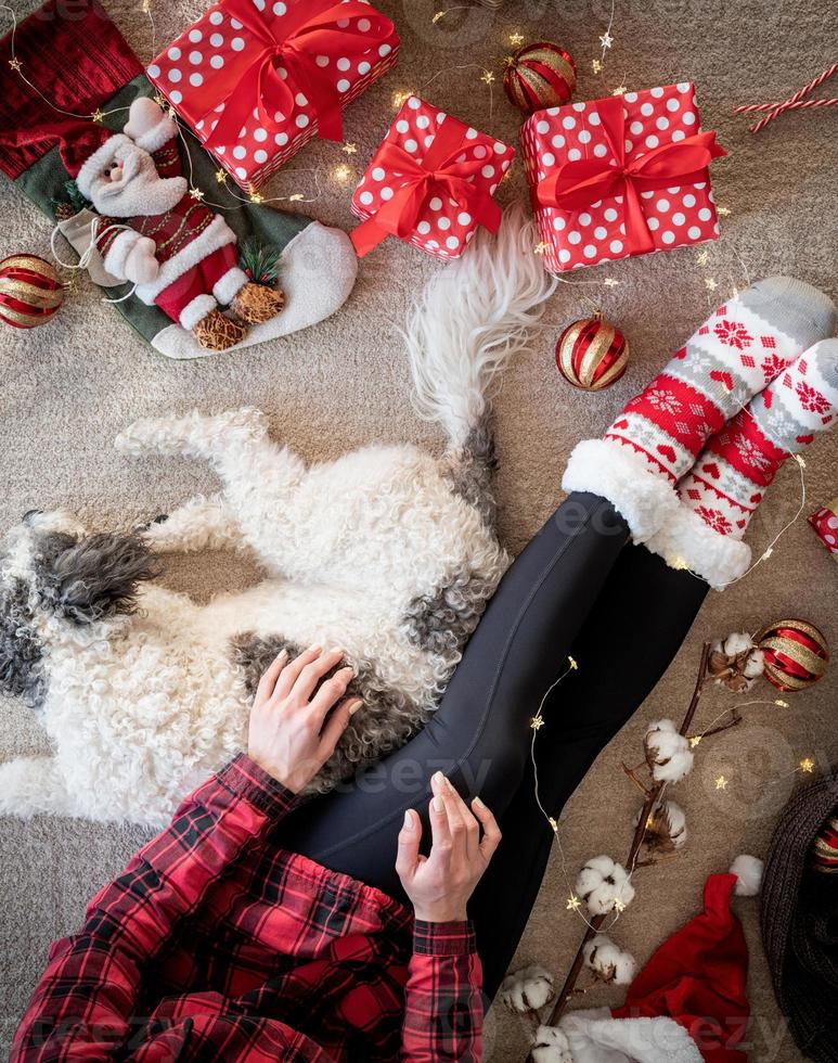 Draufsicht einer Frau in lustigen Socken, die Weihnachten mit ihrem Hund feiert foto