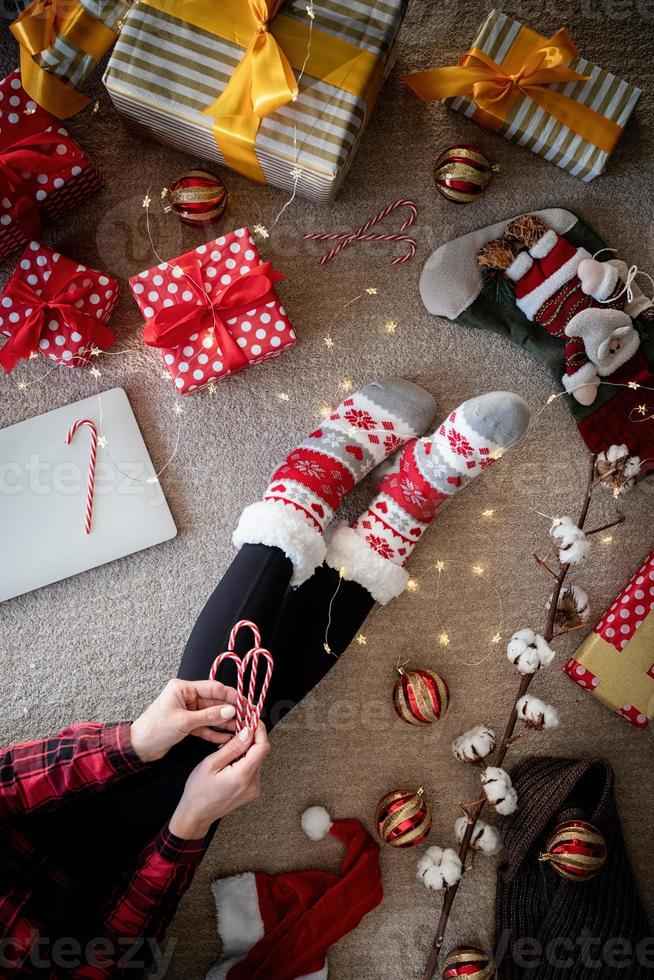 Draufsicht einer Frau in lustigen Socken, die Weihnachten zu Hause feiert foto